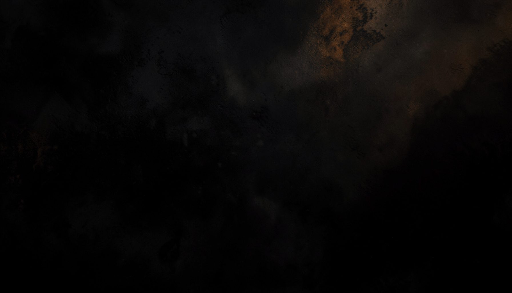 Dark atmospheric abstract composition with deep charcoal and black tones, subtle warm amber light bleeding across a moody textured surface, evoking a cinematic and contemplative mood.